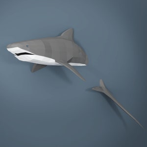 May include: A gray origami shark with a white underside. The shark is in mid-air with its tail extended behind it.