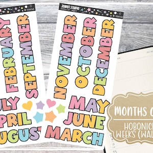 May include: Colorful sticker sheets with the months of the year in bubble letters. The stickers are in various colors, with the text "MONTHS ONLY HOBONICHI WEEKS (WALLET)" on a brown label. A planner is visible.