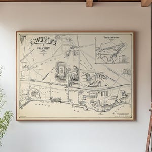 Könnte beinhalten: Eine gerahmte Vintage-Karte von Karthago mit dem Titel oben. Die Karte ist in Schwarzweiß gehalten und zeigt detaillierte Illustrationen des Stadtlayouts. Die Karte wird an einer weißen Wand in einem Raum mit Betonboden und Holzbalken angezeigt.