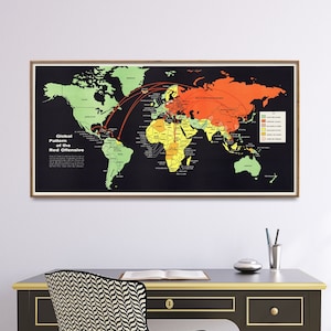 May include: A black framed world map poster with a red, orange, and yellow color scheme. The map shows the "Global Pattern of the Red Offensive" with arrows pointing from the Soviet Union to other countries. The poster is hanging on a white wall above a black desk with a chair.