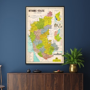 Może przedstawiać: Antyczna mapa stanu Mysore, znanego również jako "Vidhana Karnataka", przedstawiająca różne dystrykty i regiony stanu. Mapa jest oprawiona i wisi na ciemnoniebieskiej ścianie nad drewnianym kredensem.