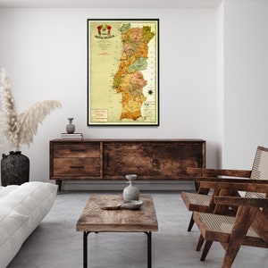 Puede incluir: Un mapa vintage de Portugal en un marco negro, colgado en una pared blanca sobre un aparador de madera. El mapa est&aacute; en tonos de amarillo, verde y marr&oacute;n, con un escudo rojo y amarillo en la parte superior. El mapa est&aacute; titulado "Portugal Continental" y muestra las diferentes provincias de Portugal.