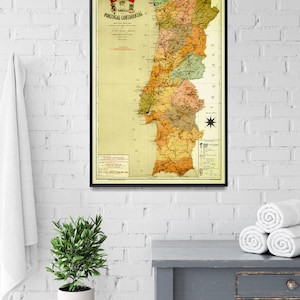 Puede incluir: Un mapa vintage de Portugal Continental, impreso en negro, rojo y verde sobre un fondo crema. El mapa est&aacute; enmarcado en negro y cuelga de una pared de ladrillo blanco.