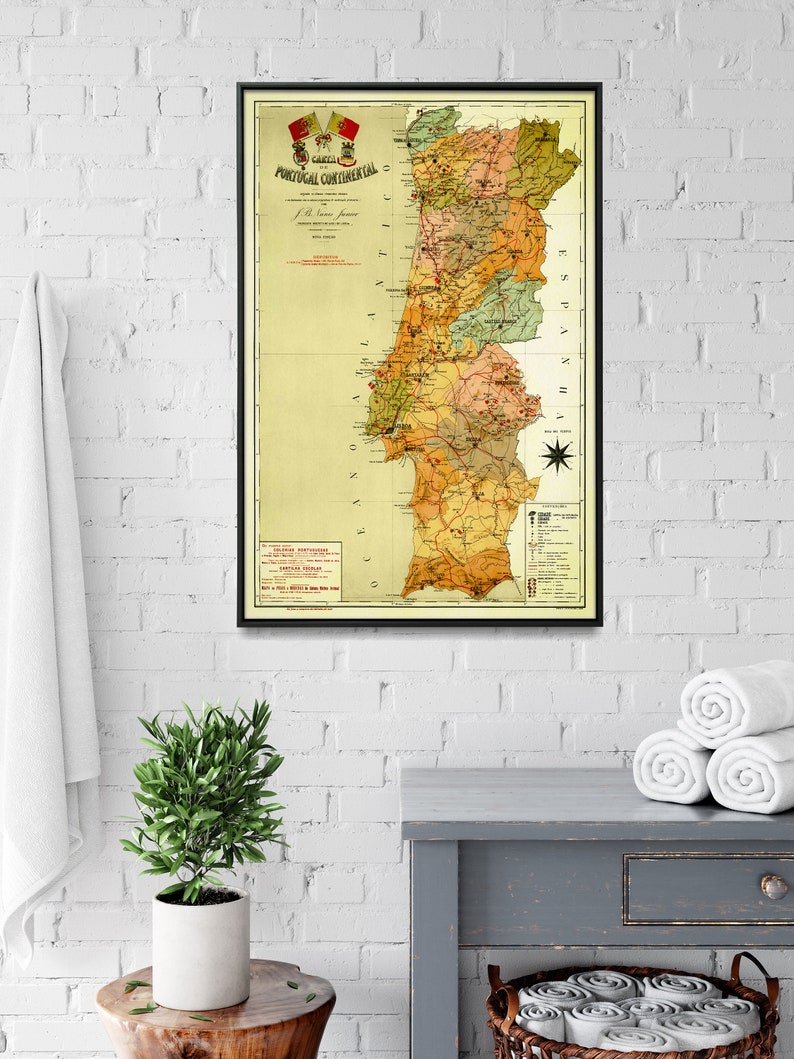 Puede incluir: Un mapa vintage de Portugal Continental, impreso en negro, rojo y verde sobre un fondo crema. El mapa est&aacute; enmarcado en negro y cuelga de una pared de ladrillo blanco.