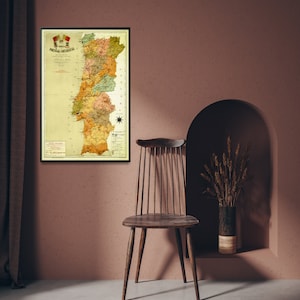 Puede incluir: Un mapa vintage de Portugal en un marco negro colgado en una pared rosa. El mapa est&aacute; en tonos de amarillo, verde y marr&oacute;n. El mapa est&aacute; titulado "Carta Physica de Portugal".