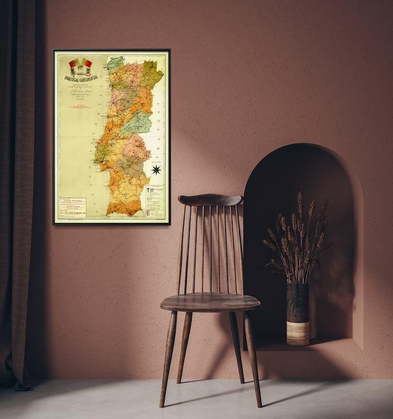 Puede incluir: Un mapa vintage de Portugal en un marco negro colgado en una pared rosa. El mapa est&aacute; en tonos de amarillo, verde y marr&oacute;n. El mapa est&aacute; titulado "Carta Physica de Portugal".
