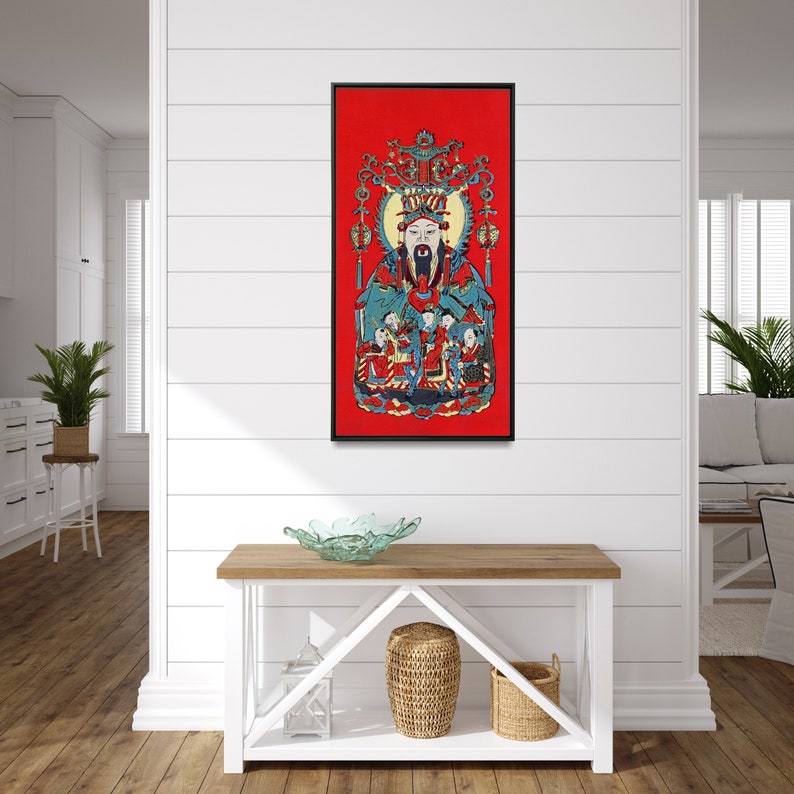 May include: A framed print of a traditional Chinese painting depicting a deity with a long beard and a crown, surrounded by other figures. The painting is on a red background with gold accents.