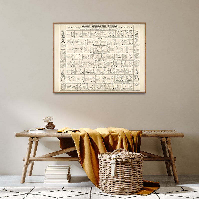 May include: A vintage black and white illustration of a home exercise chart. The chart shows a series of exercises for different muscle groups in the body. The chart is framed in a brown wooden frame and is hanging on a beige wall. A wooden bench with a yellow blanket and a wicker basket are in the foreground.