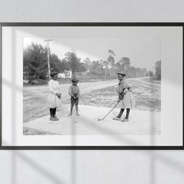Jeunes golfeurs : trois enfants afro-américains jouent au golf avec des bâtons et une pomme de pin - imprimé vintage en noir et blanc