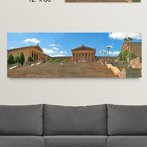 May include: Two rectangular canvas prints depicting a panoramic view of a grand building with a long staircase under a blue sky. The larger print measures 20 x 60 inches, and the smaller one is 12 x 36 inches.