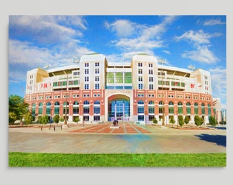 May include: A digital art print of a large stadium with a red brick facade, green accents, and a large arched entrance. The sky is blue with fluffy white clouds. The stadium has multiple levels and is set against a backdrop of a bright blue sky.