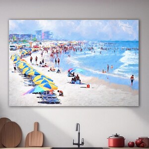 Pu&ograve; includere: Una stampa artistica rettangolare da parete che raffigura una scena di spiaggia affollata con numerosi ombrelloni a righe gialle e blu, persone che si rilassano sulla sabbia e bagnanti nell'acqua blu dell'oceano, sopra un piano cucina.