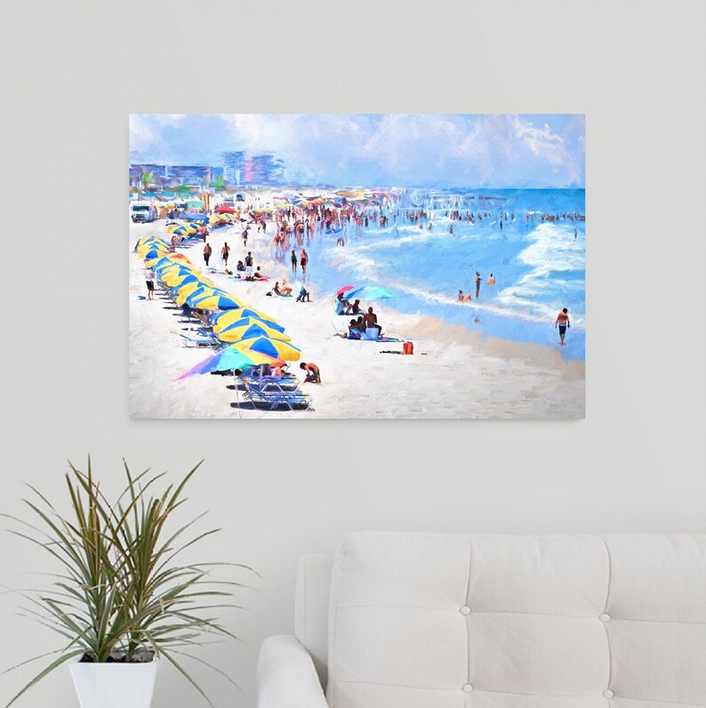 Pu&ograve; includere: Una stampa artistica da parete rettangolare che raffigura una soleggiata scena di spiaggia con numerose persone, file di ombrelloni a righe blu e gialle, sedie a sdraio e sabbia bianca che incontra le onde blu dell'oceano sotto un cielo azzurro.