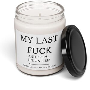 May include: A white candle in a clear glass jar with a black lid. The label reads "MY LAST FUCK AND, OOPS, IT'S ON FIRE! SMELLS LIKE - I'M ALL OUT OF FUCKS."
