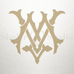 May include: A gold monogram with the letters "M" and "V" intertwined in a decorative, ornate design.