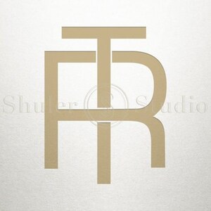May include: Gold monogram with the letters "F", "T", and "R" intertwined.
