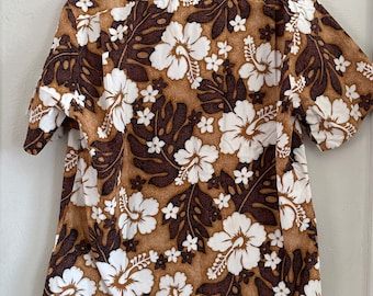 Könnte beinhalten: Ein braunes und weißes Kurzarmhemd mit einem Blumenmuster. Das Hemd hat einen braunen Hintergrund mit weißen Hibiskusblüten und braunen Blättern.