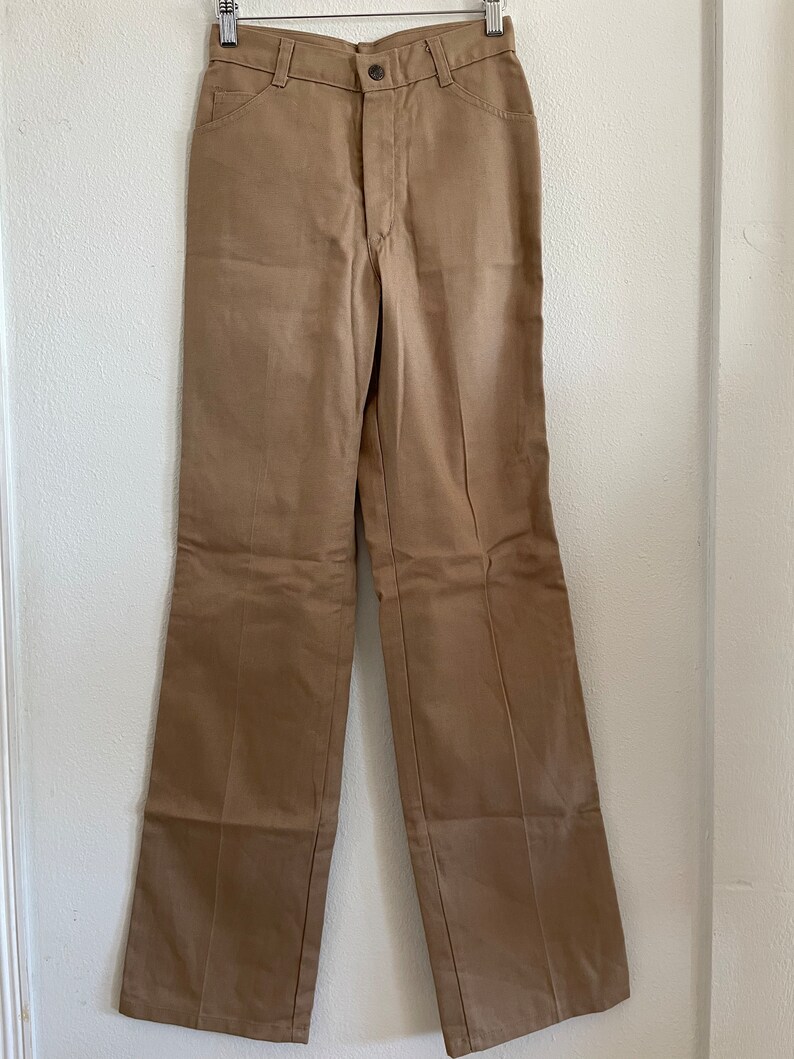 Op de afbeelding: Een lichtbruine broek met een hoge taille en een rechte pijp.
