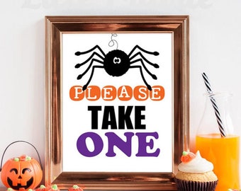 May include: A framed sign with a black spider illustration and the text PLEASE TAKE ONE in orange, black, and purple. The frame is metallic copper. The sign features a white background and is displayed with a pumpkin bucket and a cupcake.