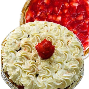May include: Two fruit pies in foil pans. One pie is topped with swirls of white frosting and a red strawberry rose. The other pie has a red strawberry topping. The crusts are golden brown.
