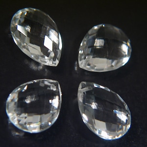 May include: Four clear teardrop-shaped crystal prisms with faceted edges.