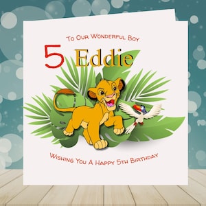 May include: A birthday card with a cartoon lion cub and a bird set against green leaves. The card says "To Our Wonderful Boy" and "Wishing You a Happy 5th Birthday" with the name "Eddie". The number 5 is in red.