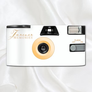 May include: White disposable camera with a gold inscription that reads "Forever Memories". The camera has a yellow lens and a flash that can be turned on or off.