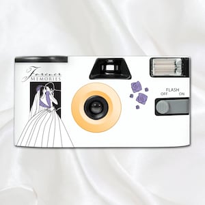 May include: White disposable camera with a black lens, orange lens ring, and a flash. The camera features a graphic of a bride and groom with the text "Forever Memories" and purple rose accents.