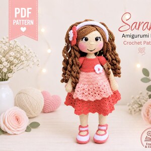 May include: A handmade amigurumi doll named Sarahi, crocheted in shades of red, pink, and brown. The doll has curly brown hair, a white headband, and a red dress. The image includes the text "PDF PATTERN" and "Sarahi Amigurumi Doll Crochet Pattern".