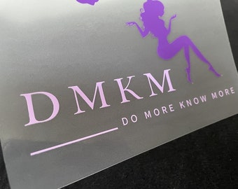 以下が含まれることがあります： 薄いグレーの背景に、白い文字で「DMKM DO MORE KNOW MORE」と書かれた、座っている女性の紫色のシルエットです。