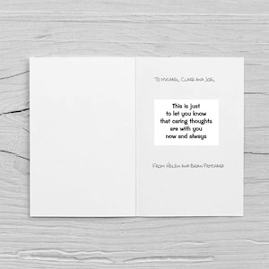 Op de afbeelding: Een open witte wenskaart met tekst. De kaart leest "TO MICHAEL, CLARE AND JOE," en bevat de boodschap "This is just to let you know that caring thoughts are with you now and always." De kaart is ondertekend met "FROM HELEN AND BRIAN PRITCHARD."