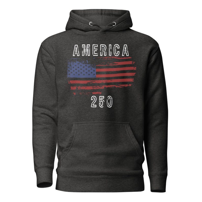 May include: Vintage Black colored hoodie featuring a America 250 with a distressed American Flag. The hoodie has a kangaroo pocket and a drawstring hood. The graphic is detailed with a distressed effect.