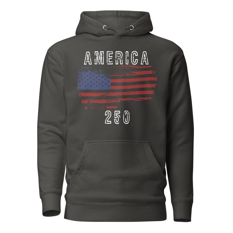 May include: Charcoal Heather colored hoodie featuring a America 250 with a distressed American Flag. The hoodie has a kangaroo pocket and a drawstring hood. The graphic is detailed with a distressed effect.