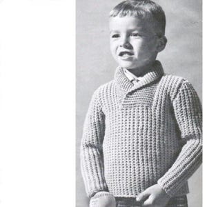 Può includere: Immagine in bianco e nero di un bambino che indossa un maglione di maglia chiaro e strutturato con collo a scialle. Il maglione ha maniche lunghe e orlo a coste. Il bambino tiene una palla da baseball.