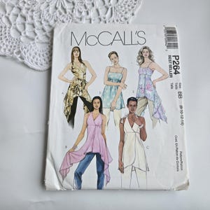 May include: A vintage McCall's sewing pattern, featuring illustrations of various women's tops and a size range of 8-14. The pattern cover displays the text "BEST SELLER" and "P264 BB". The cover is white with a slight crease.