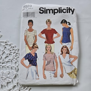 Peut inclure: Une pochette de patron de couture Simplicity, numéro 8523, taille K 8, 10, 12. Le devant présente des illustrations de six modèles de hauts différents, incluant des motifs floraux, unis, à pois et rayés, avec des manches courtes ou sans manches.