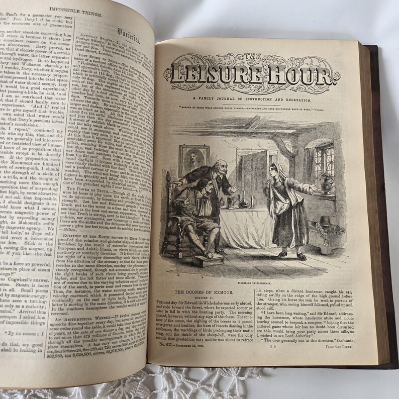 Op de afbeelding: Een open oud boek met tekst en illustraties. De rechterpagina toont een gedetailleerde zwart-wit illustratie van een sc&egrave;ne met figuren in een kamer. De titel "THE LEISURE HOUR" is bovenaan zichtbaar.