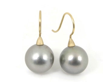 May include: A pair of silver pearl earrings with gold hooks. The pearls are round and smooth.