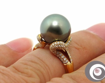 May include: A gold ring with a large black pearl and diamond accents.