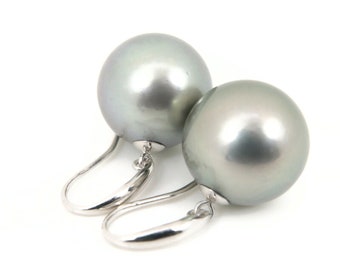 May include: A pair of silver hoop earrings with large, round, gray pearls.