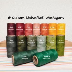 Könnte beinhalten: Eine Sammlung von 0,5 mm Linhasita Wachsgarnspulen in verschiedenen Farben, darunter Rot, Orange, Gelb und Grüntöne. Jede Spule ist mit einer Nummer und einem Farbnamen beschriftet. Die Spulen sind in drei Reihen auf einer gestreiften Fläche angeordnet.