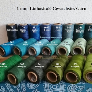 Könnte beinhalten: Eine Sammlung von 1 mm gewachsten Baumwollgarnrollen in verschiedenen Blautönen, Grüntönen und Türkis. Die Rollen sind mit Nummern und Farbnamen in Deutsch beschriftet.