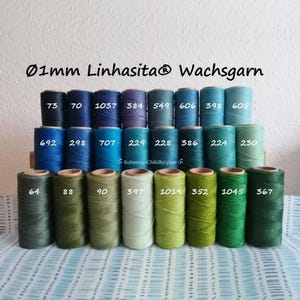 Könnte beinhalten: Eine Sammlung von Spulen mit gewachstem Faden in verschiedenen Farben, darunter Blau-, Grün- und Brauntöne. Der Text "Ø1mm Linhasita® Wachsgarn" ist oben zu sehen. Jede Spule ist mit einer Nummer versehen.