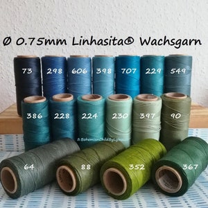 Könnte beinhalten: Eine Sammlung von 14 Spulen gewachsten Garns in Blautönen, Grüntönen und Türkis. Die Spulen sind mit Zahlen von 64 bis 707 beschriftet. Der Text "Ø 0.75mm Linhasita® Wachsgarn" ist oben im Bild gedruckt.