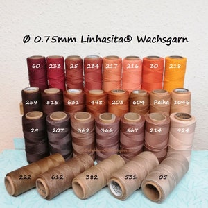 Könnte beinhalten: Eine Sammlung von 0,75 mm gewachsten Garnrollen in verschiedenen Brauntönen, Orange- und Gelbtönen. Die Rollen sind mit Nummern gekennzeichnet, darunter 60, 233, 25, 234, 217, 216, 30, 218, 2,59, 515, 631, 498, 203, 604, Palha, 1046, 29, 207, 362, 366, 567, 214, 924, 222, 612, 382, 531 und 05.