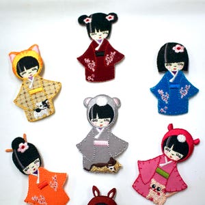 May include: Set of seven embroidered iron-on patches featuring adorable cartoon girls in various outfits and colours. Each patch includes a small animal companion.
