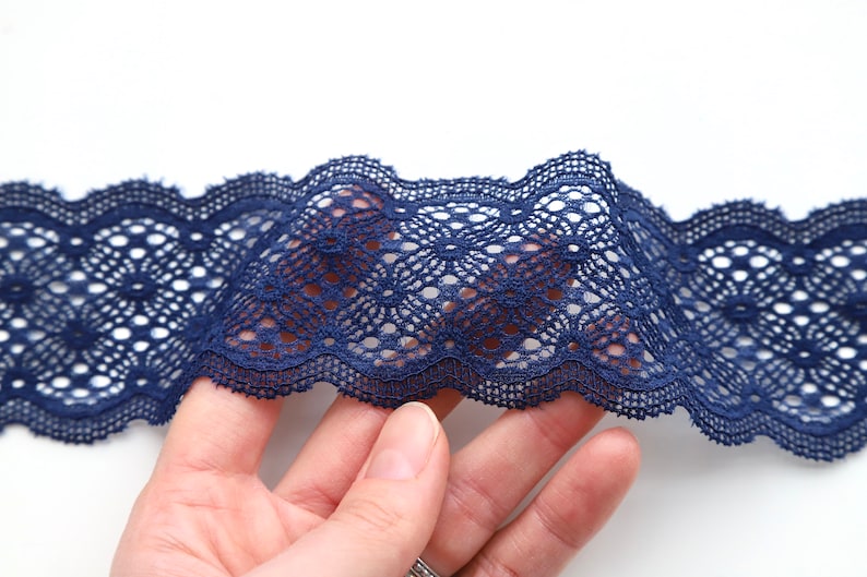 Puede incluir: Borde de encaje azul marino con un delicado patr&oacute;n floral. El encaje es suave y flexible, lo que lo hace ideal para agregar un toque de elegancia a cualquier proyecto.