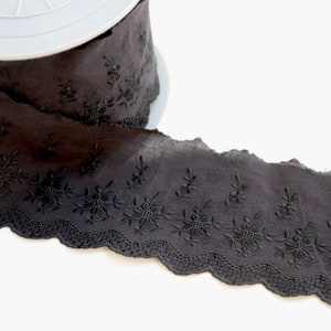 Peut inclure: Galon de dentelle en coton noir avec un bord festonn&eacute; et un motif floral brod&eacute;.