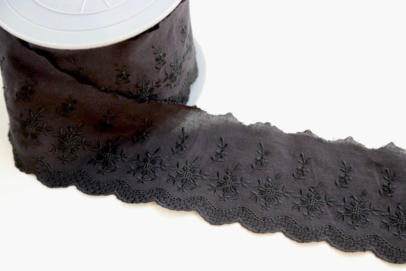 Peut inclure: Galon de dentelle en coton noir avec un bord festonn&eacute; et un motif floral brod&eacute;.