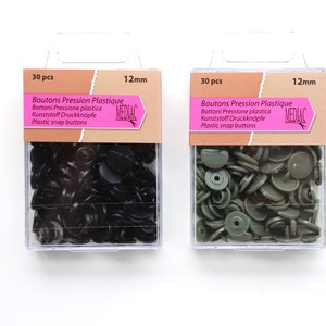 K&ouml;nnte beinhalten: Zwei Packungen mit je 30 schwarzen und gr&uuml;nen Kunststoff-Druckkn&ouml;pfen, jeweils 12 mm im Durchmesser. Die Packungen sind mit "Boutons Pression Plastique" und "MEDIAC" beschriftet.